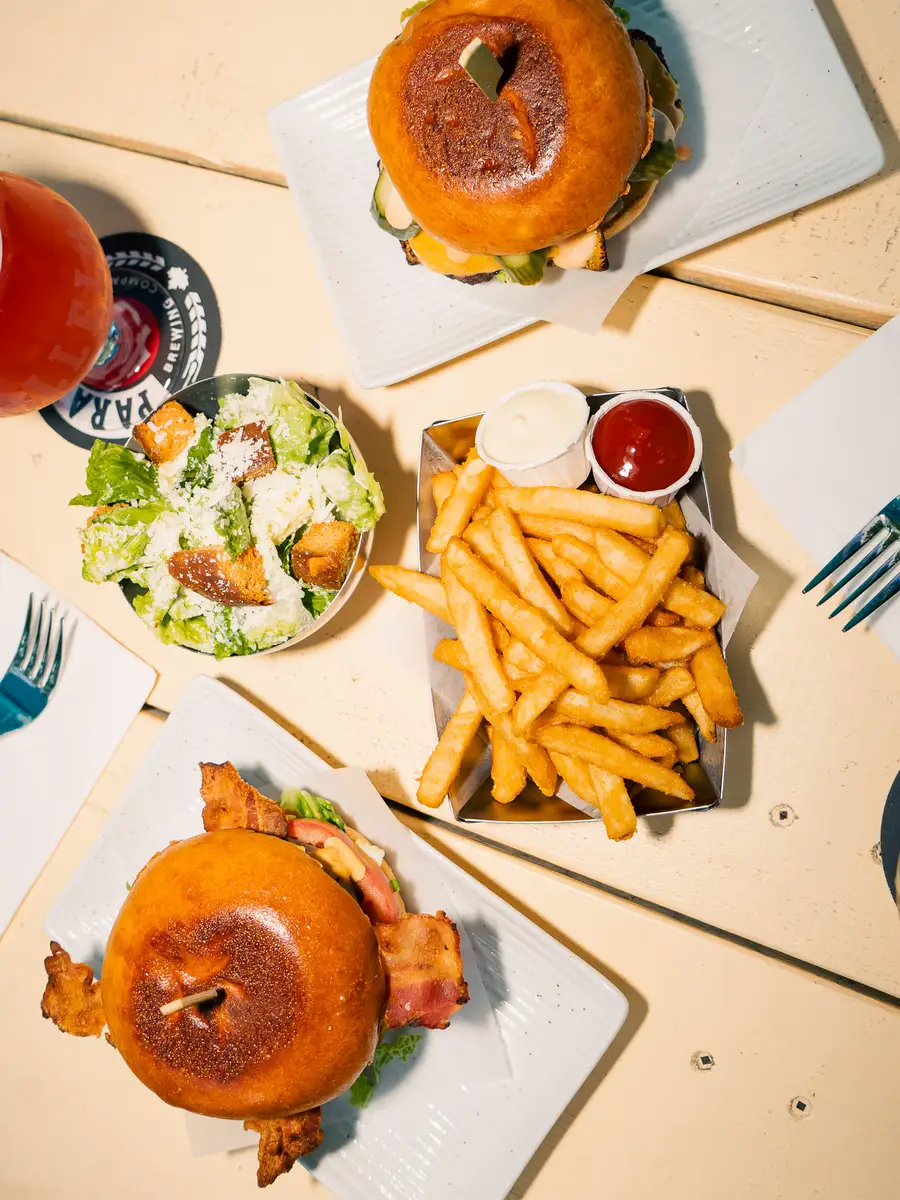 Street Kitchen spread — burgers, fries and caesar salad on the patio